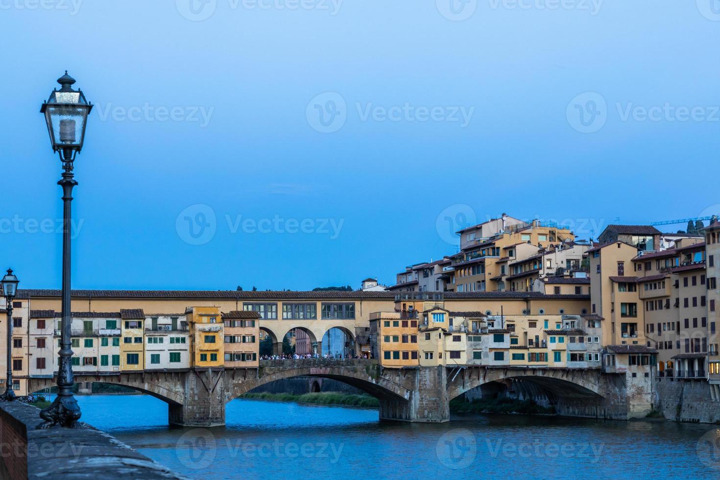 pôr do sol na ponte vecchio - ponte velha - em florença, itália. incrível luz azul antes do anoitecer. foto