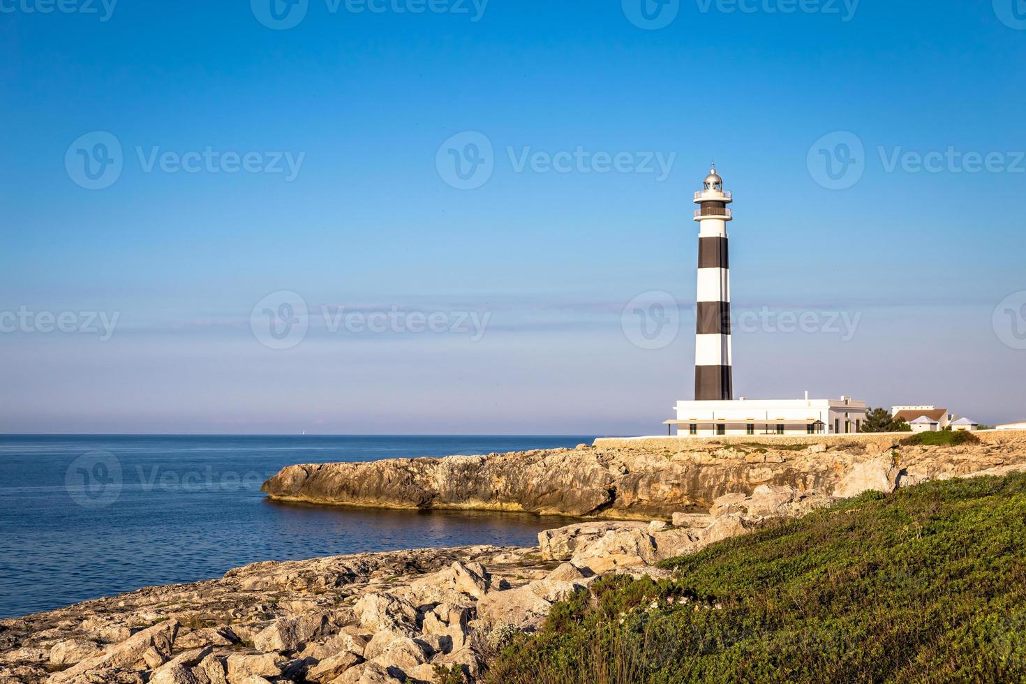 farol cênico artrutx ao pôr do sol em minorca, espanha foto