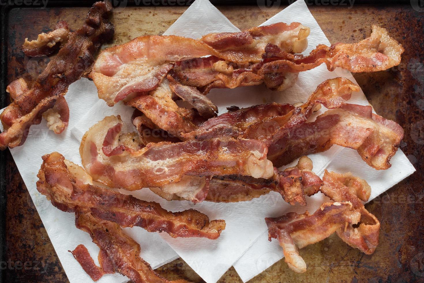 tiras de bacon fritas crocantes em papel toalha postura plana foto