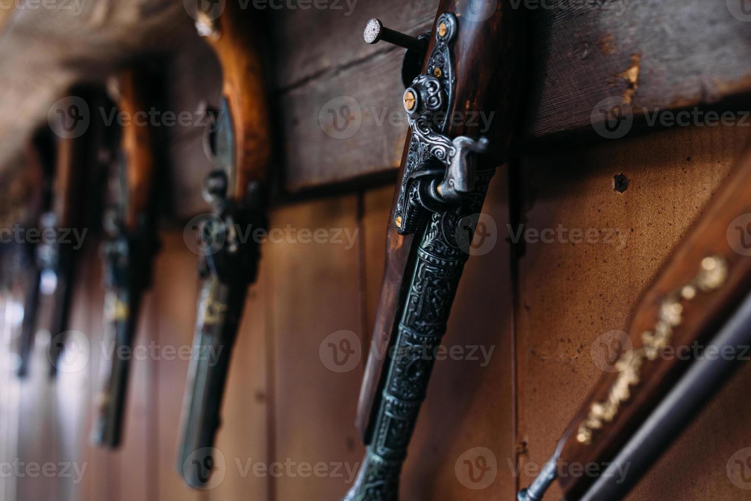 um conjunto de pistolas antigas na prateleira de uma loja de presentes. armas medievais. foto