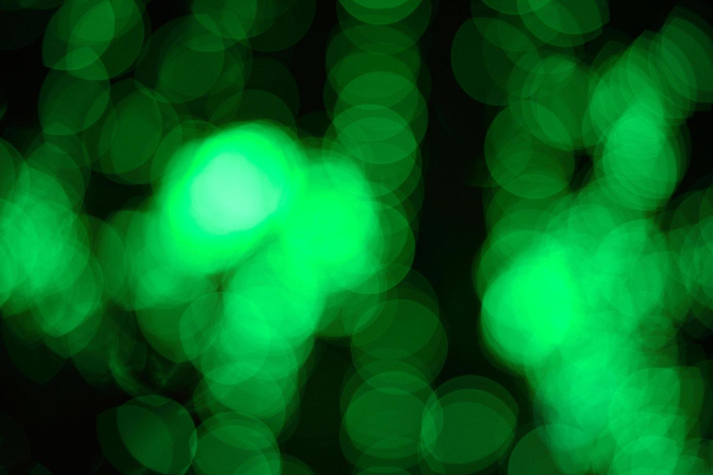 bokeh verde abstrato sobre fundo preto e luzes à noite foto
