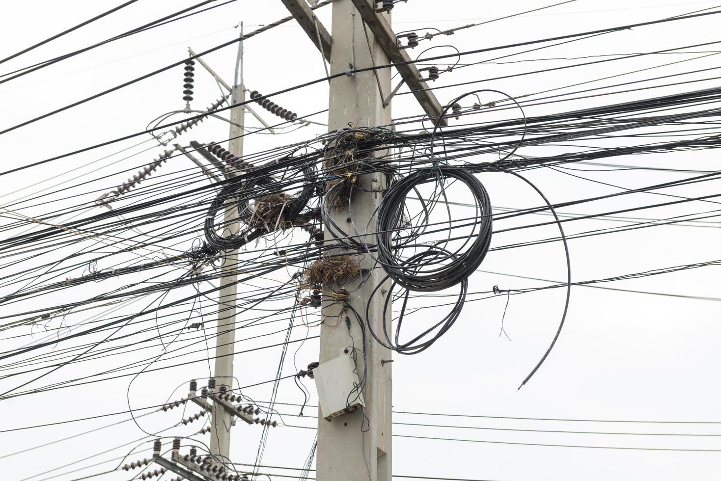 cabo e fios bagunçados no poste de eletricidade foto