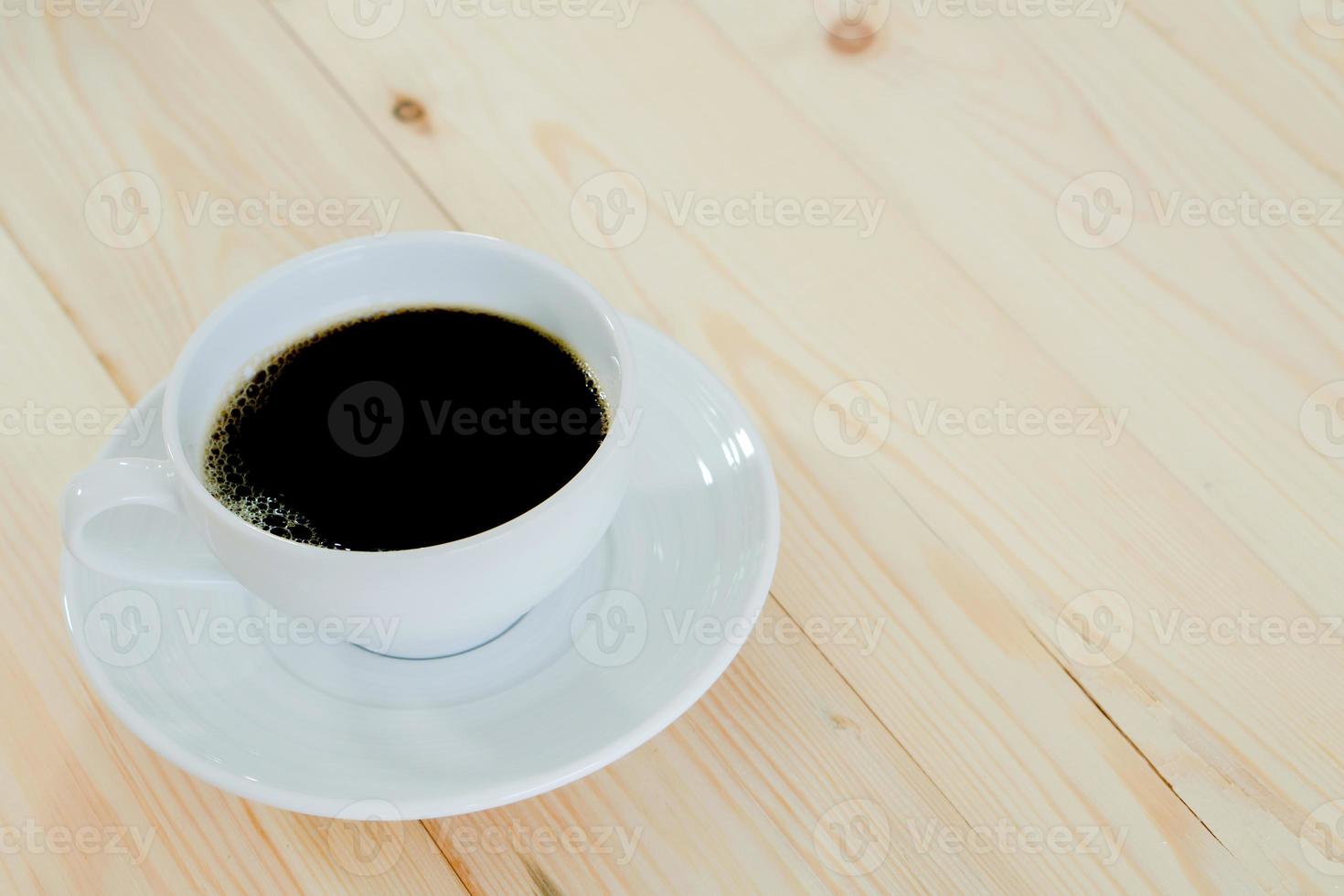 xícara de café preto sobre fundo de madeira foto