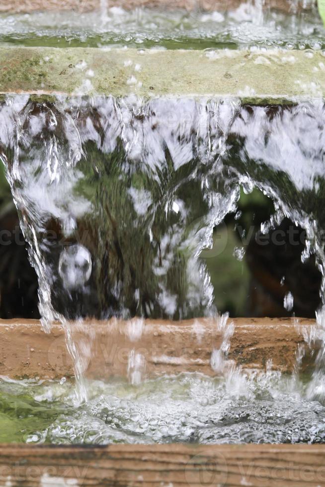 respingar gotas de água e cascata de bolhas como pano de fundo o conceito de frescura da água e bolhas de ar na superfície da água. foto