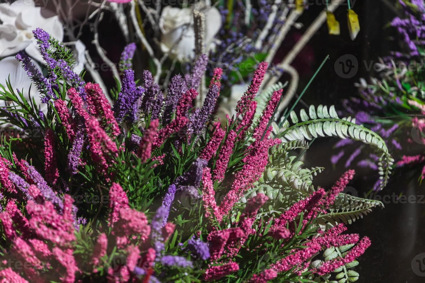 bouquet roxo artificial com uma variedade de cores. hortênsias, folhas, orquídeas. fundo de flores foto