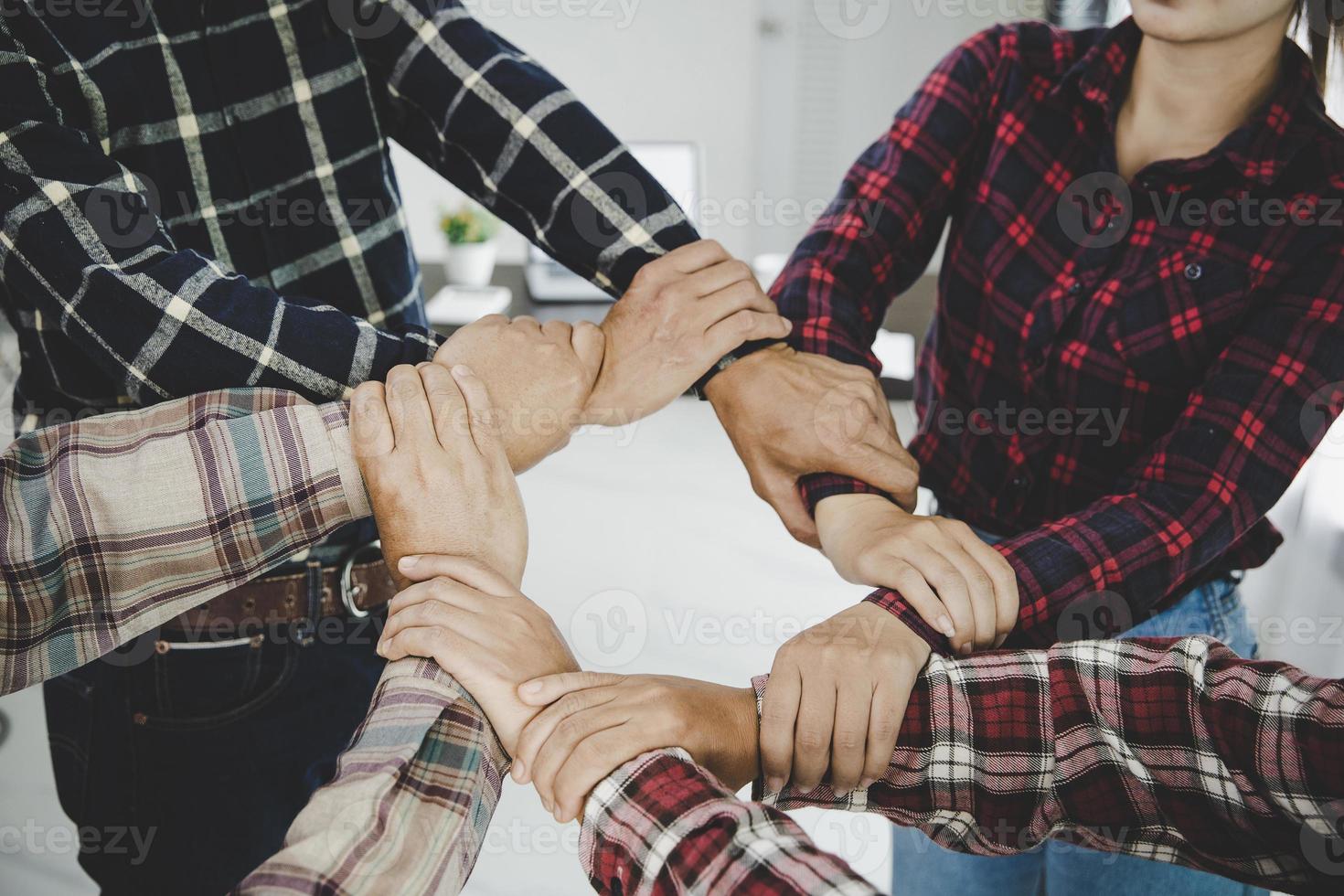 jovens empresários juntando as mãos foto