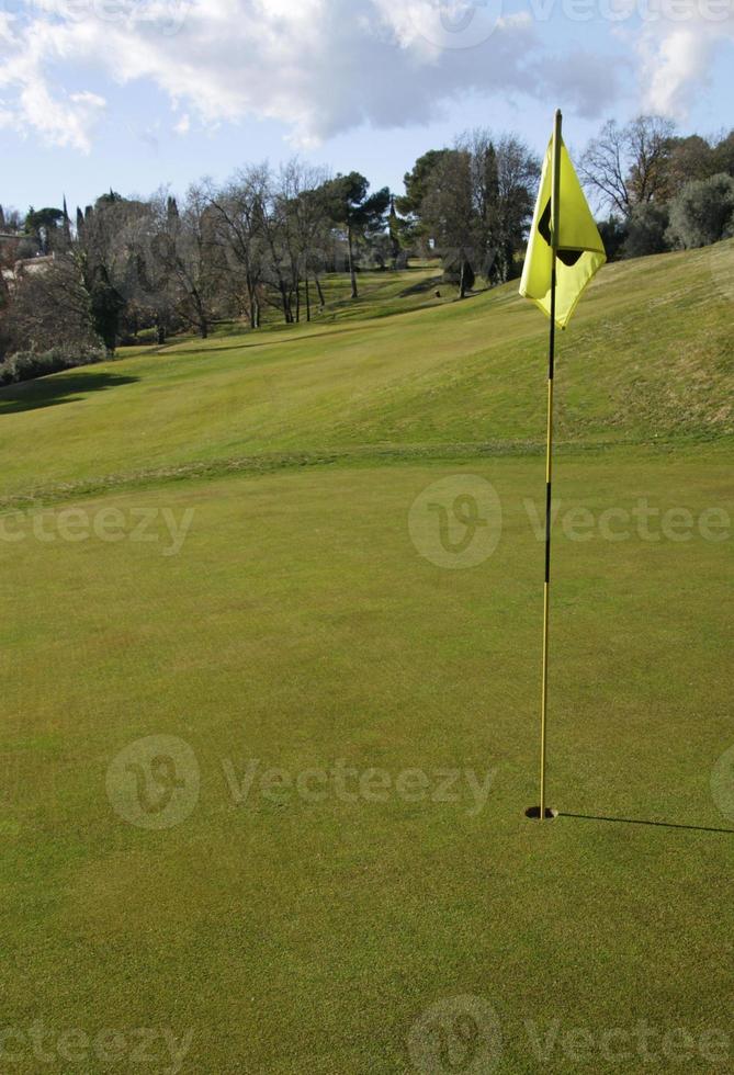 campo de golfe com vara de bandeira em um dia ensolarado foto