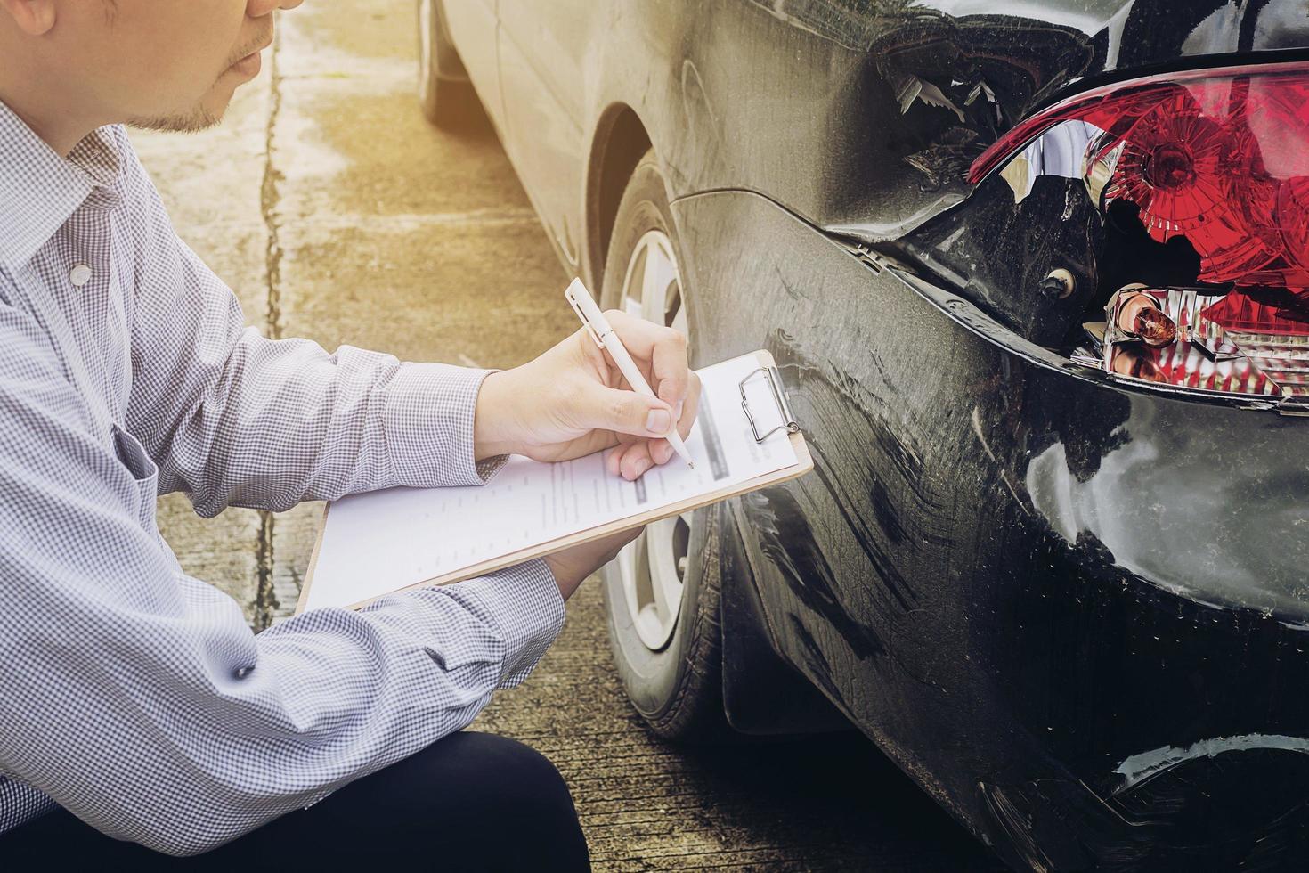 agente de seguros trabalhando no processo de reclamação de acidente de carro foto