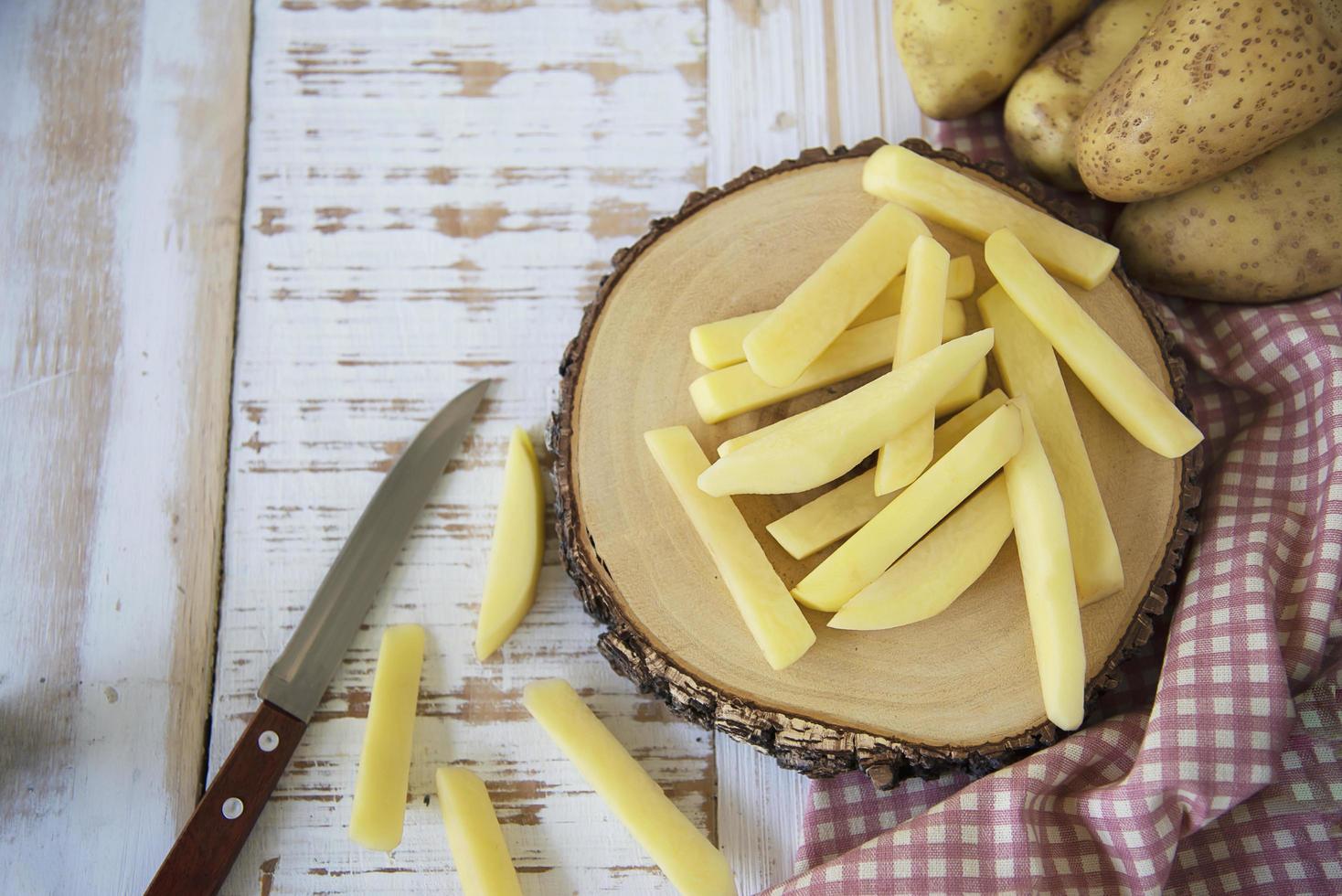 palito de batata fatiado pronto para fazer batatas fritas - conceito tradicional de preparação de alimentos foto