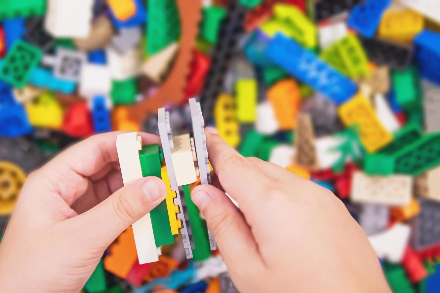 menino joga quebra-cabeça de bloco de brinquedo colorido para prática cerebral foto