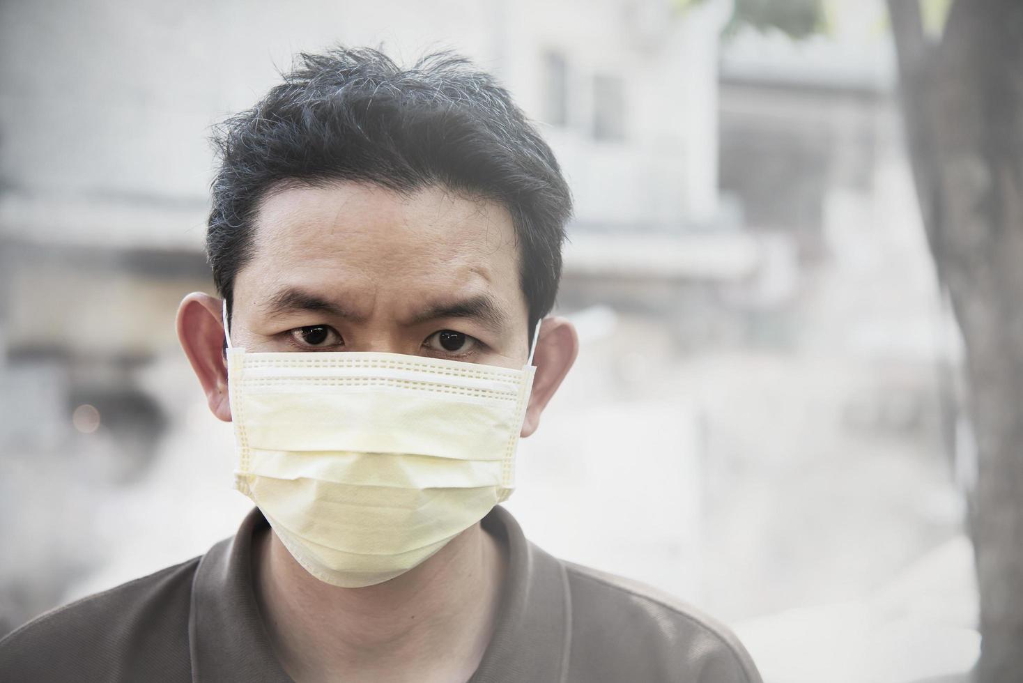 homem usando máscara protege poeira fina no ambiente de poluição do ar - pessoas com equipamentos de proteção para o conceito de poluição do ar foto