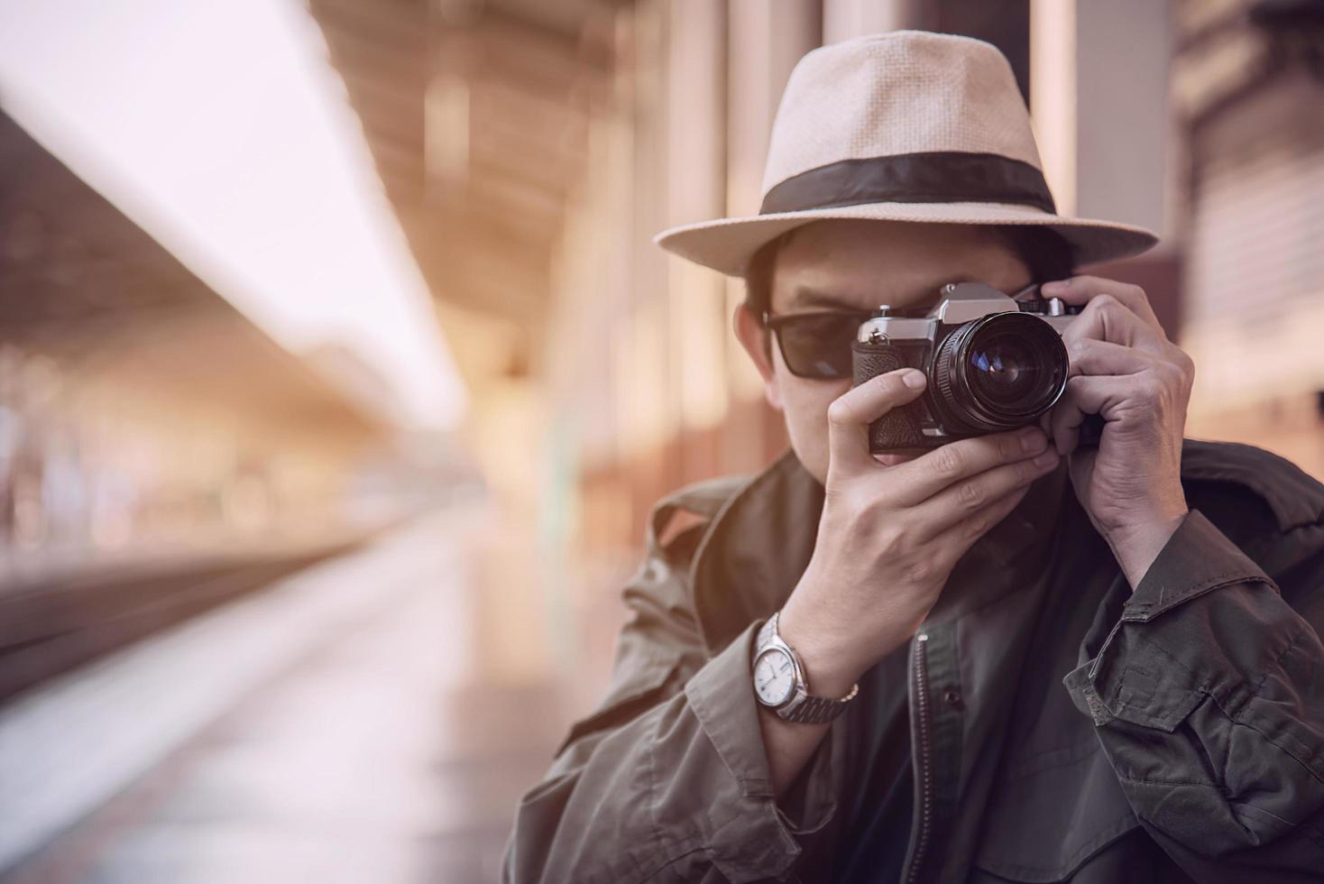 homem de viagem espera trem na plataforma - atividades de estilo de vida de férias de pessoas no conceito de transporte de estação de trem foto