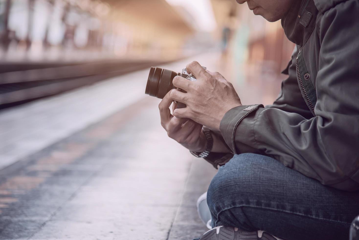 homem de viagem espera trem na plataforma - atividades de estilo de vida de férias de pessoas no conceito de transporte de estação de trem foto