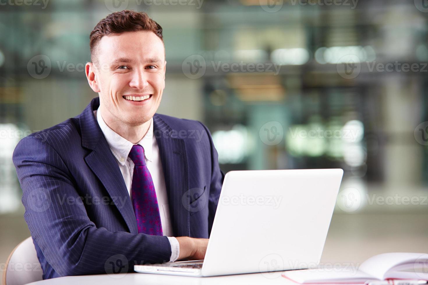 jovem empresário caucasiano usando computador portátil no trabalho foto