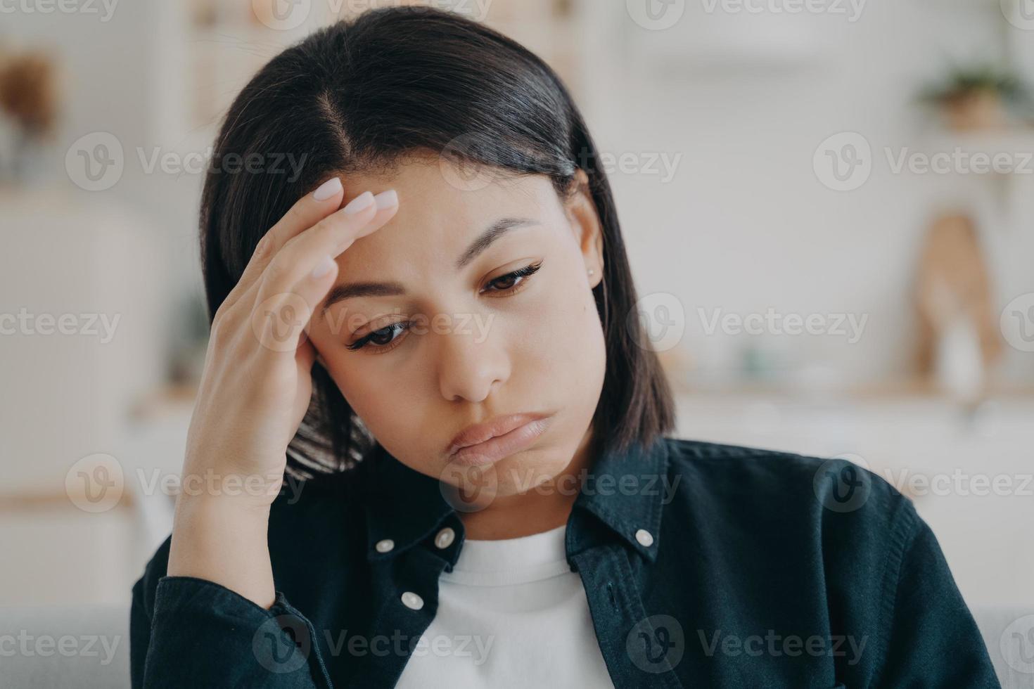 mulher doente cansada tem dor de cabeça. jovem toca a testa com os dedos e sofre o problema. foto