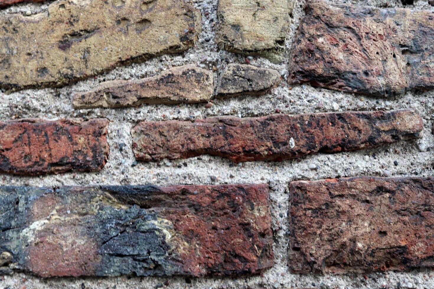 parede de tijolos antigos. textura do antigo fundo panorâmico da parede de tijolos resistidos foto