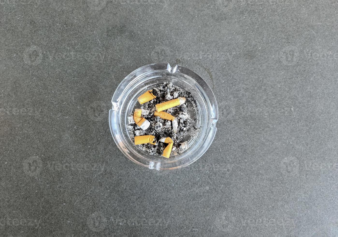 vista superior do cinzeiro cheio de pontas de cigarro. foto