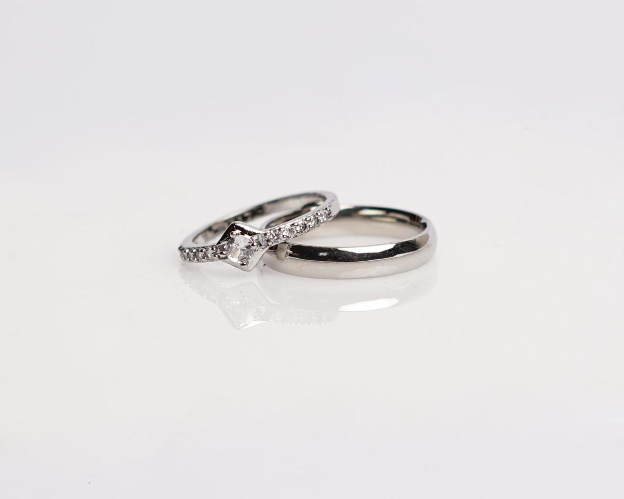 anel de joias com diamantes. anéis de casamento que têm profundo significado e significado. anel de noivado com pedras preciosas. anel de casamento isolado no fundo branco, desfoque de foco. par em ouro, prata, preto. foto