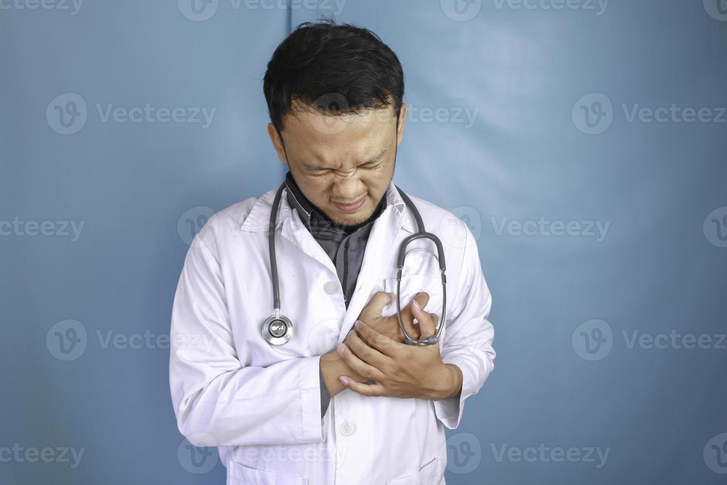um retrato de um jovem médico asiático parece com dor no peito foto