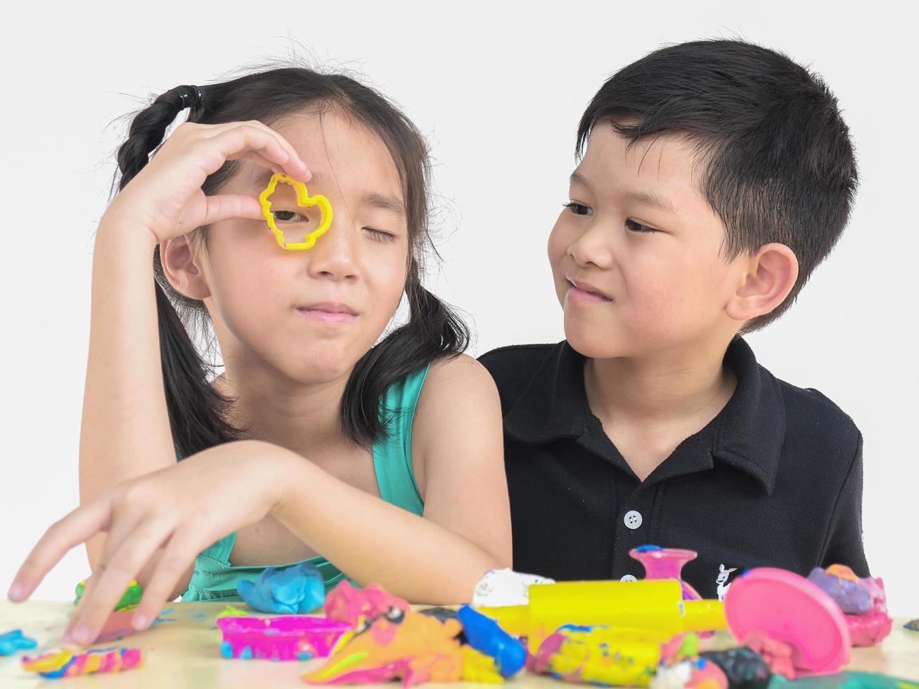 foco seletivo de crianças asiáticas felizes jogando brinquedo de barro colorido foto