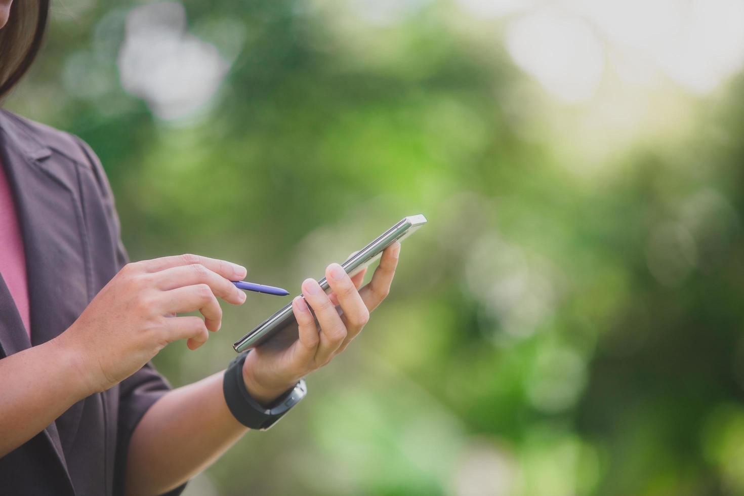 mulher de negócios ao telefone no parque ao lado da cidade foto