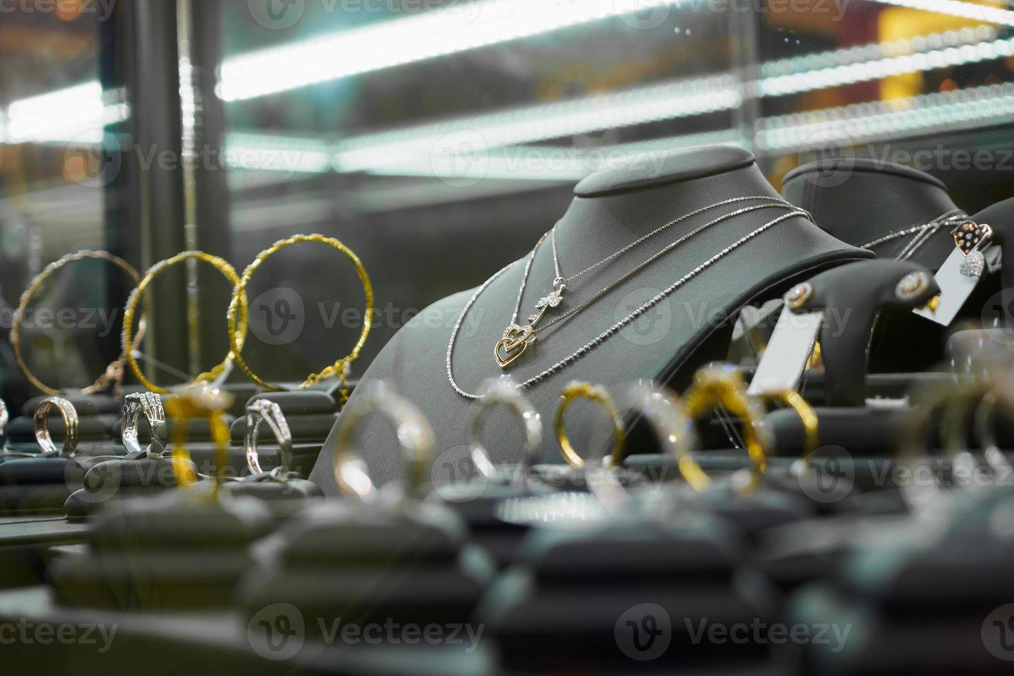 loja de diamantes de joias de ouro com anéis e colares em forma de coração em loja de varejo de luxo foto