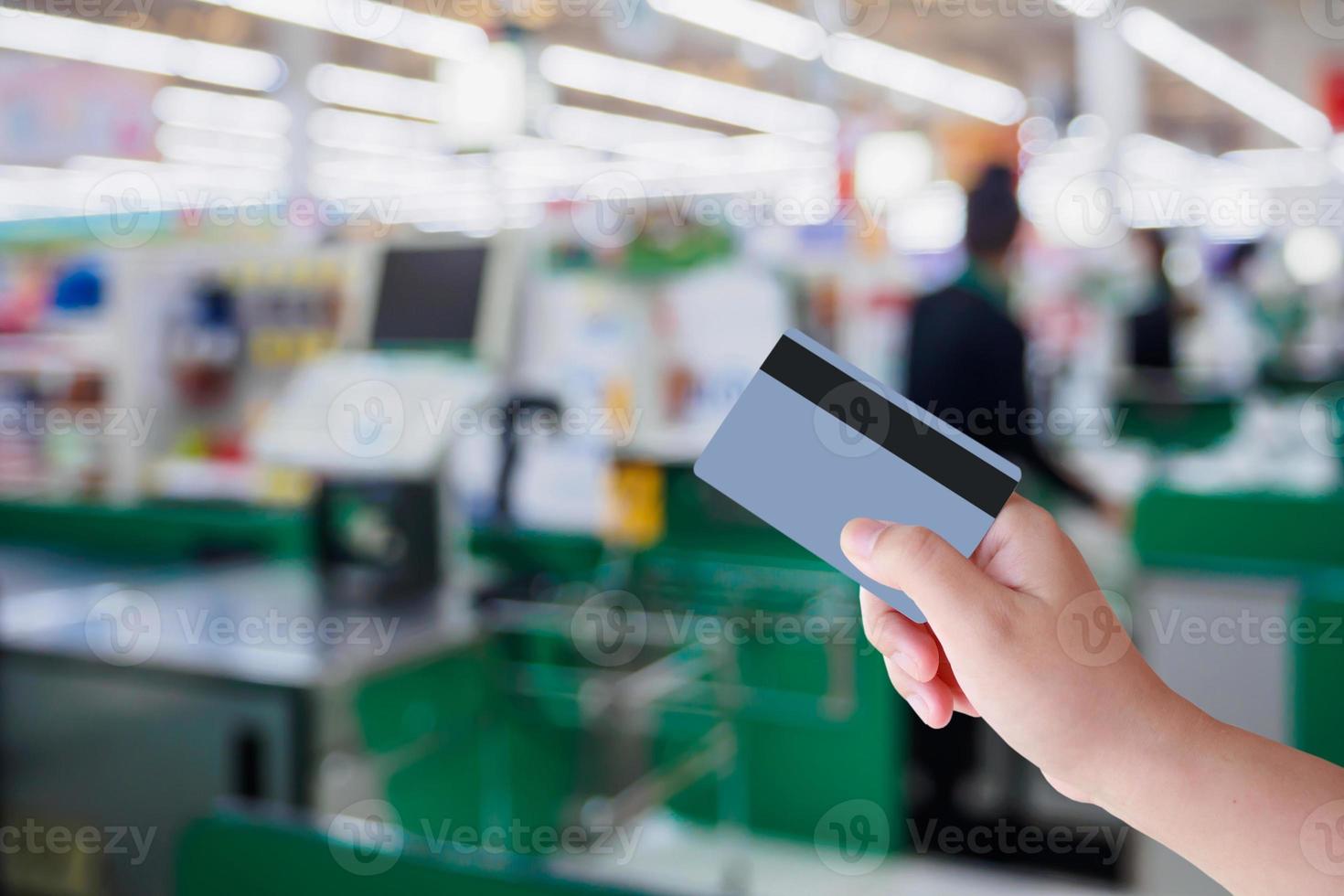 pagando com cartão de crédito no caixa do supermercado foto