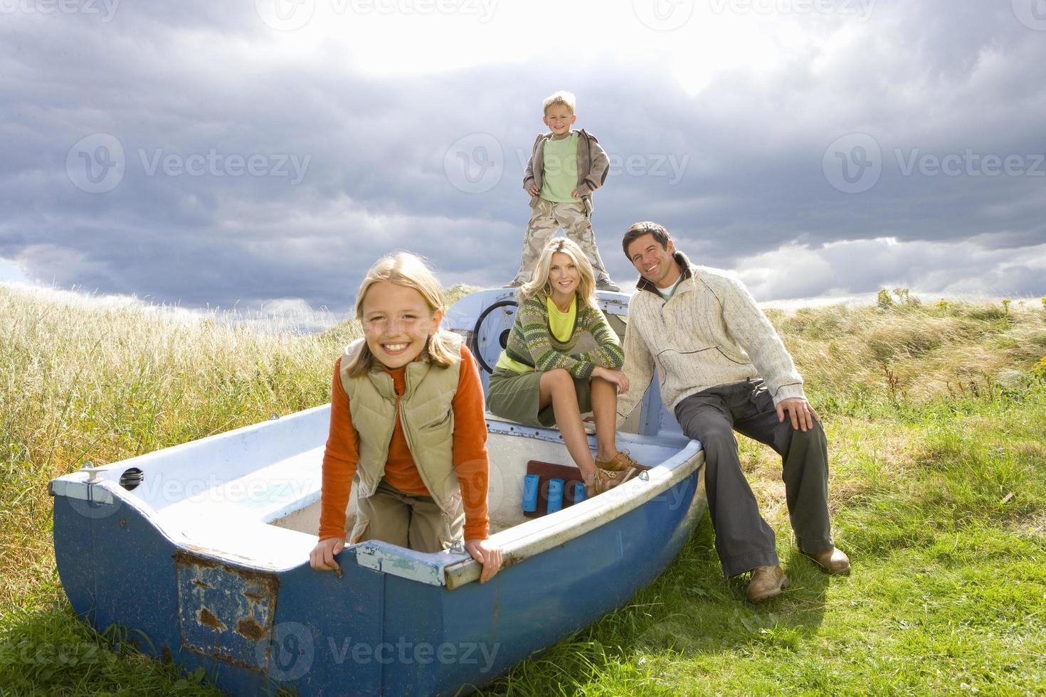 família jovem sentado no barco foto