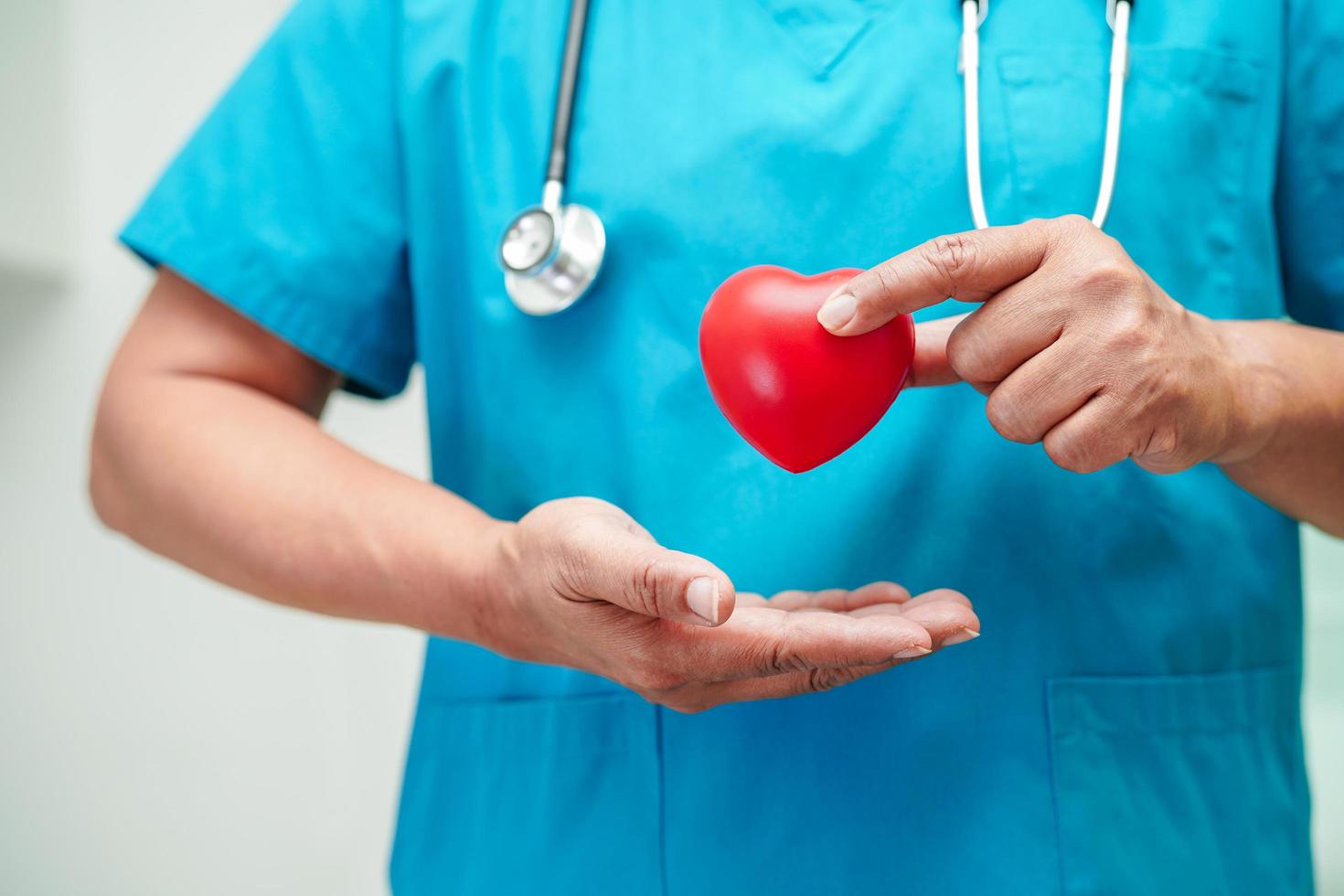 médico de mulher asiática segurando coração vermelho para saúde no hospital. foto