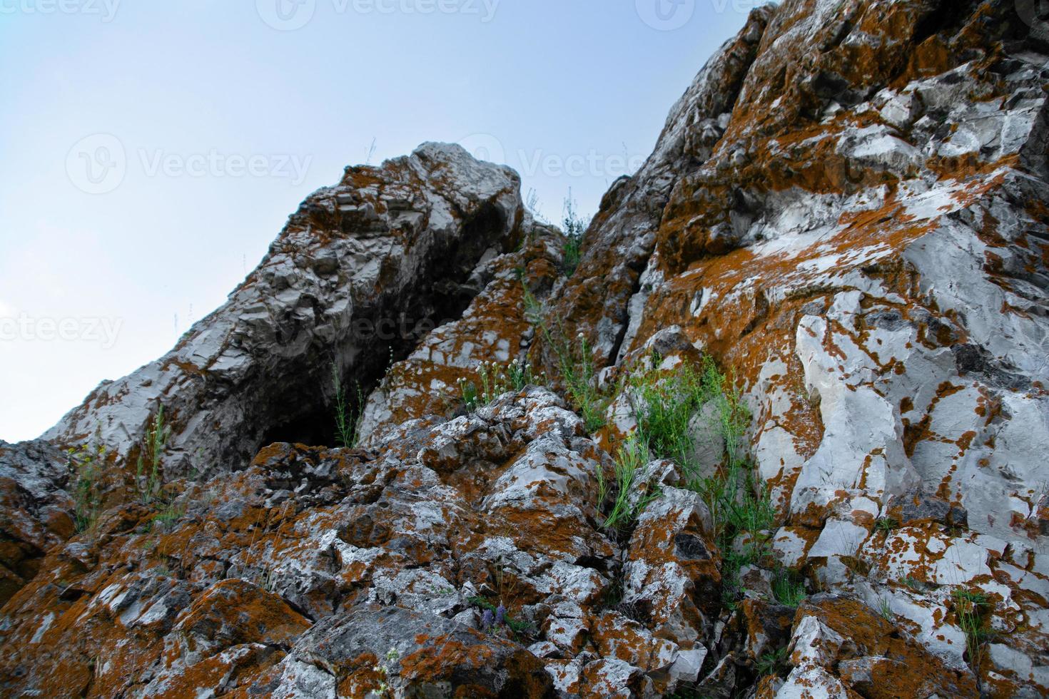 rock close-up com grama e céu azul foto