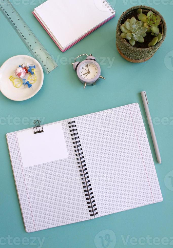 caderno em branco para escrever em espirais em um fundo azul, postura plana, o fim da motivação, negócios, construção de objetivos com espaço industrial negativo e espaço de cópia foto