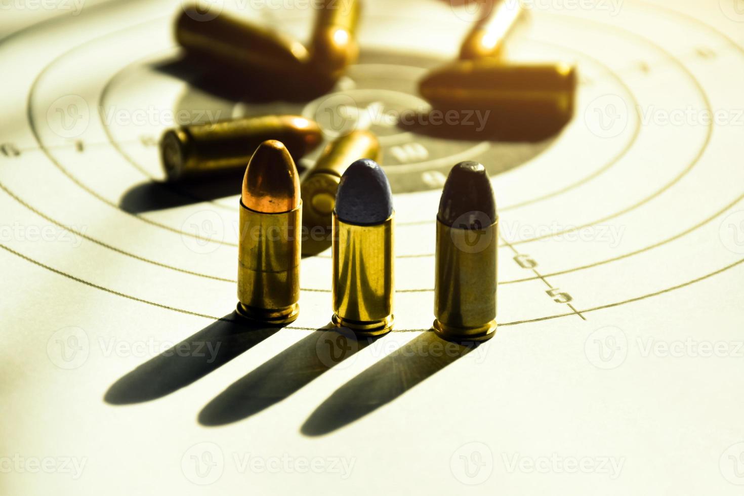 Balas de 9 mm e estojo de bala de 9 mm em papel de tiro ao alvo, foco suave e seletivo foto
