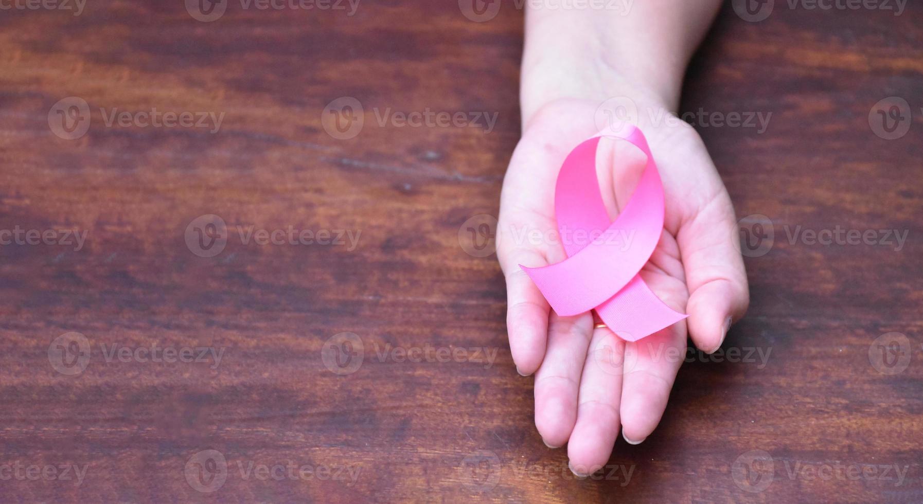 fita rosa na mão, símbolo da campanha mundial contra o câncer de mama feminino. foto