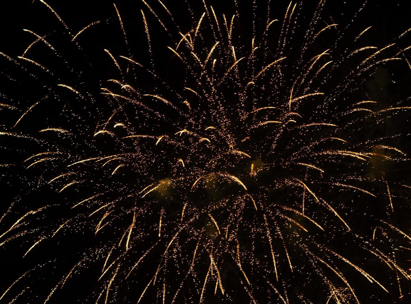 muitas faíscas no tempo fogos de artifício no céu noturno foto