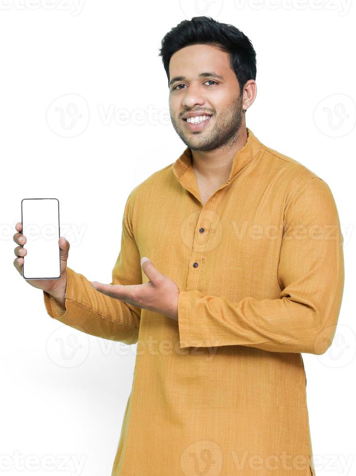 retrato de um jovem alegre vestindo kurta em fundo isolado, mostrando o celular de tela em branco. foto