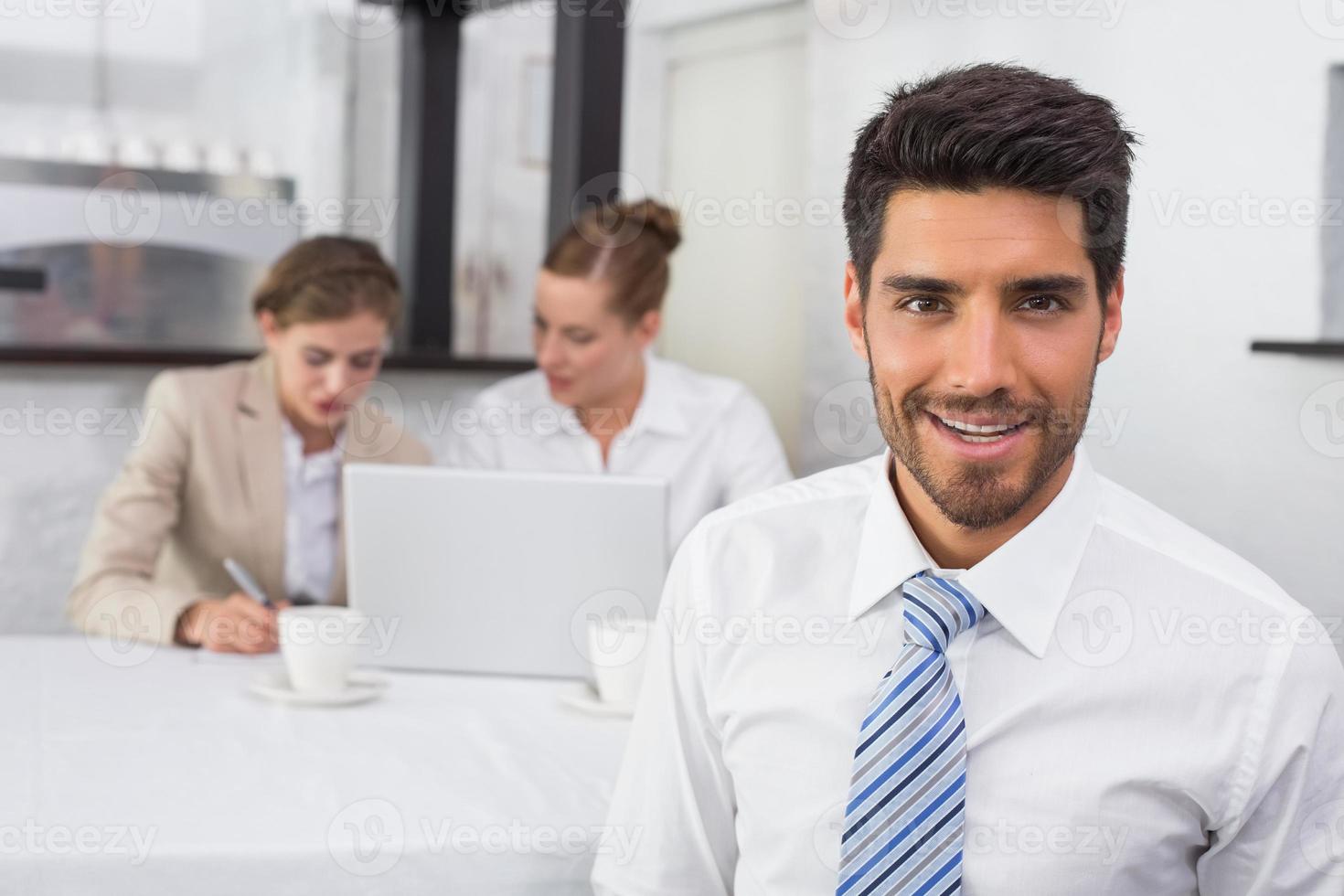 empresário sorridente com colegas na mesa de escritório foto