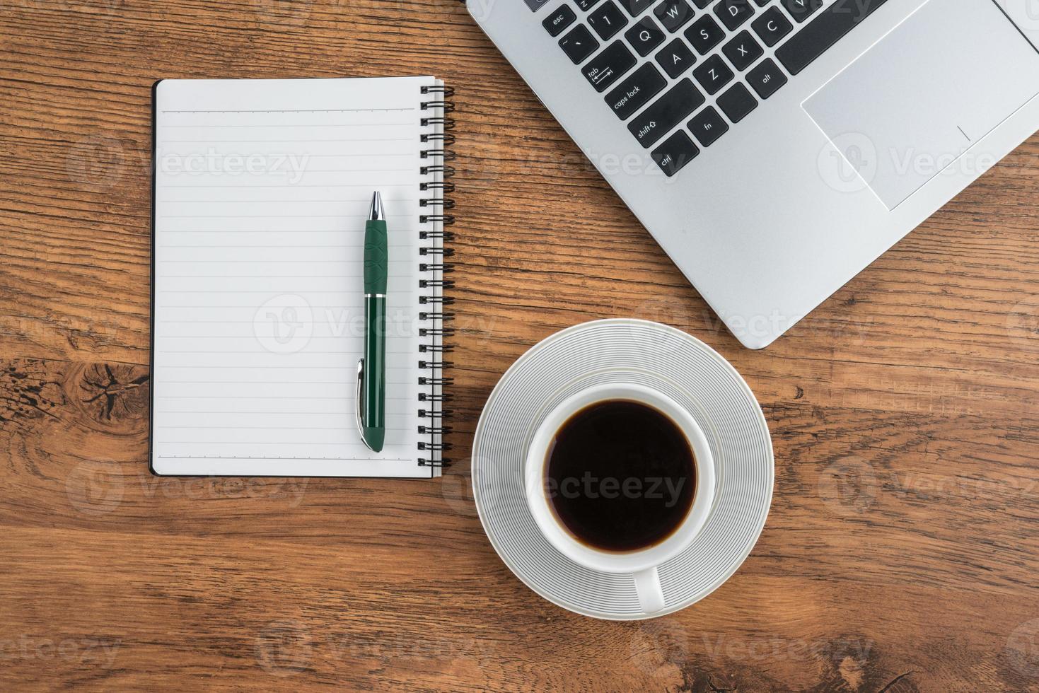 xícara de laptop, notebook e café na mesa de trabalho foto