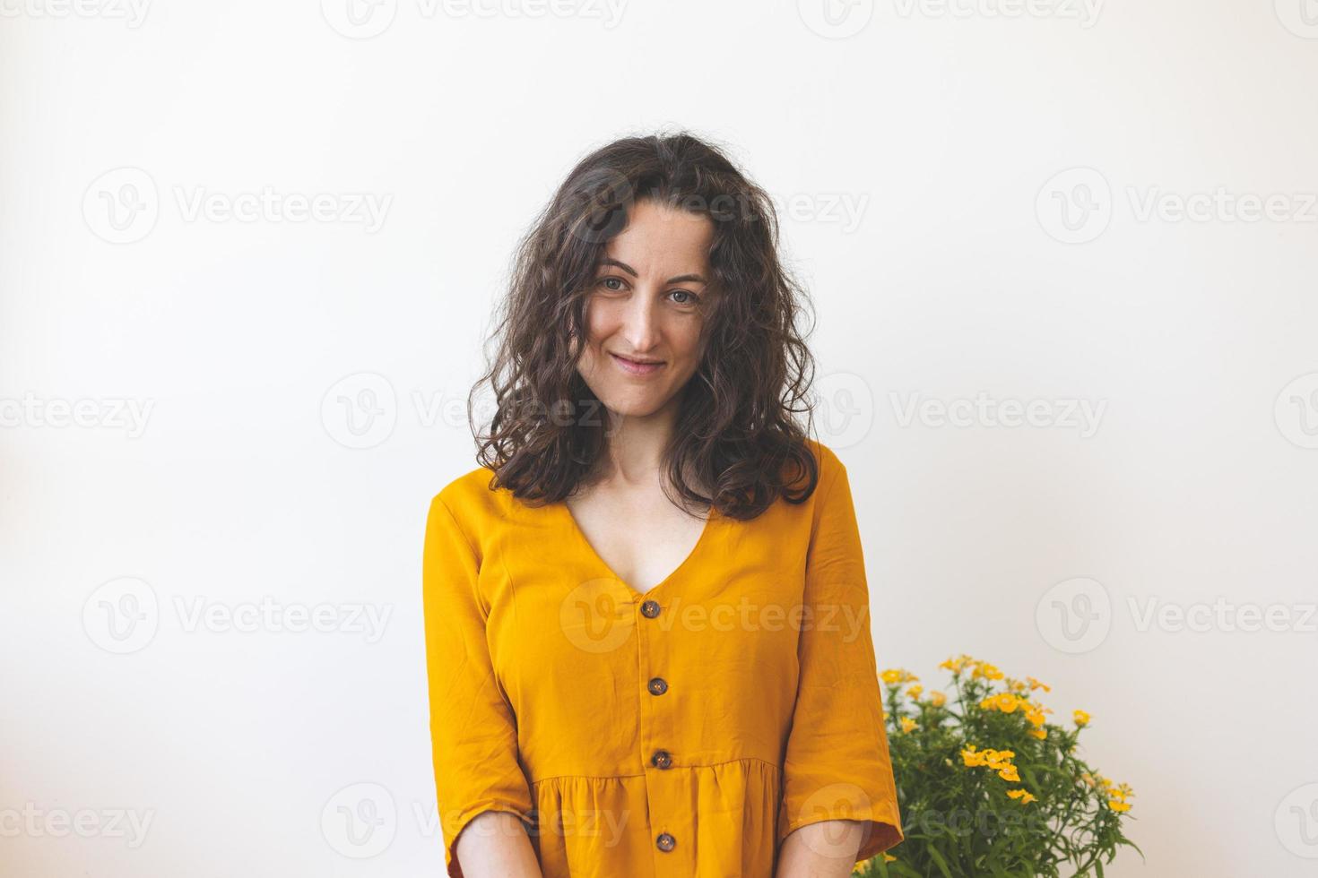 uma mulher e um pote com uma planta com flores foto