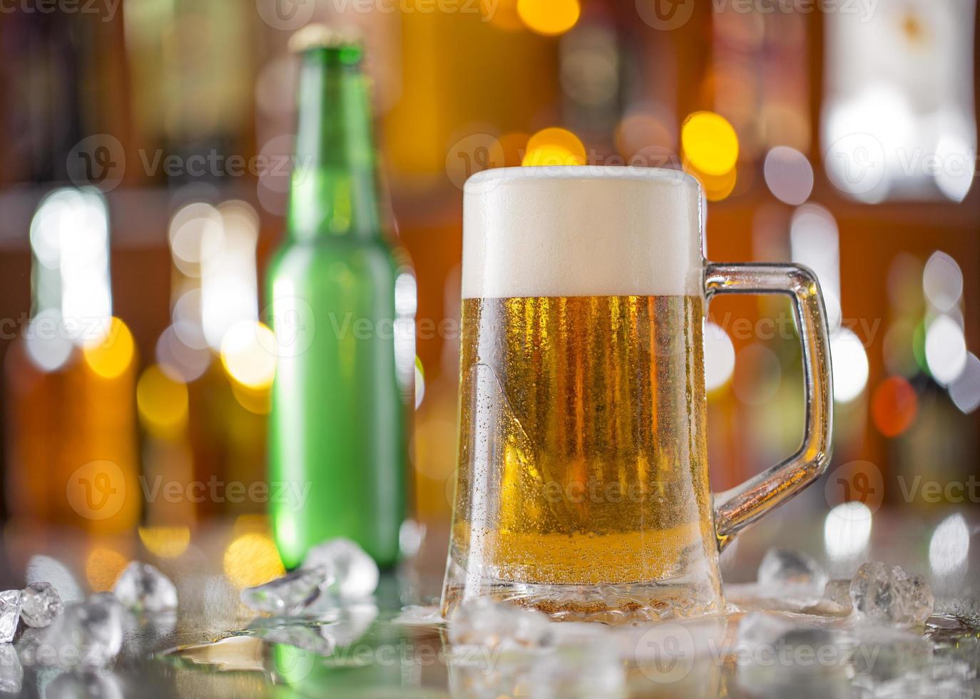 garrafa de cerveja com copo na mesa de bar foto