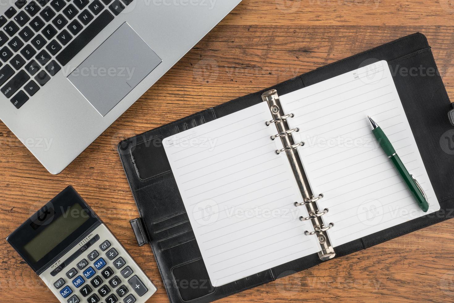 caderno e caneta com calculadora em cima da mesa foto