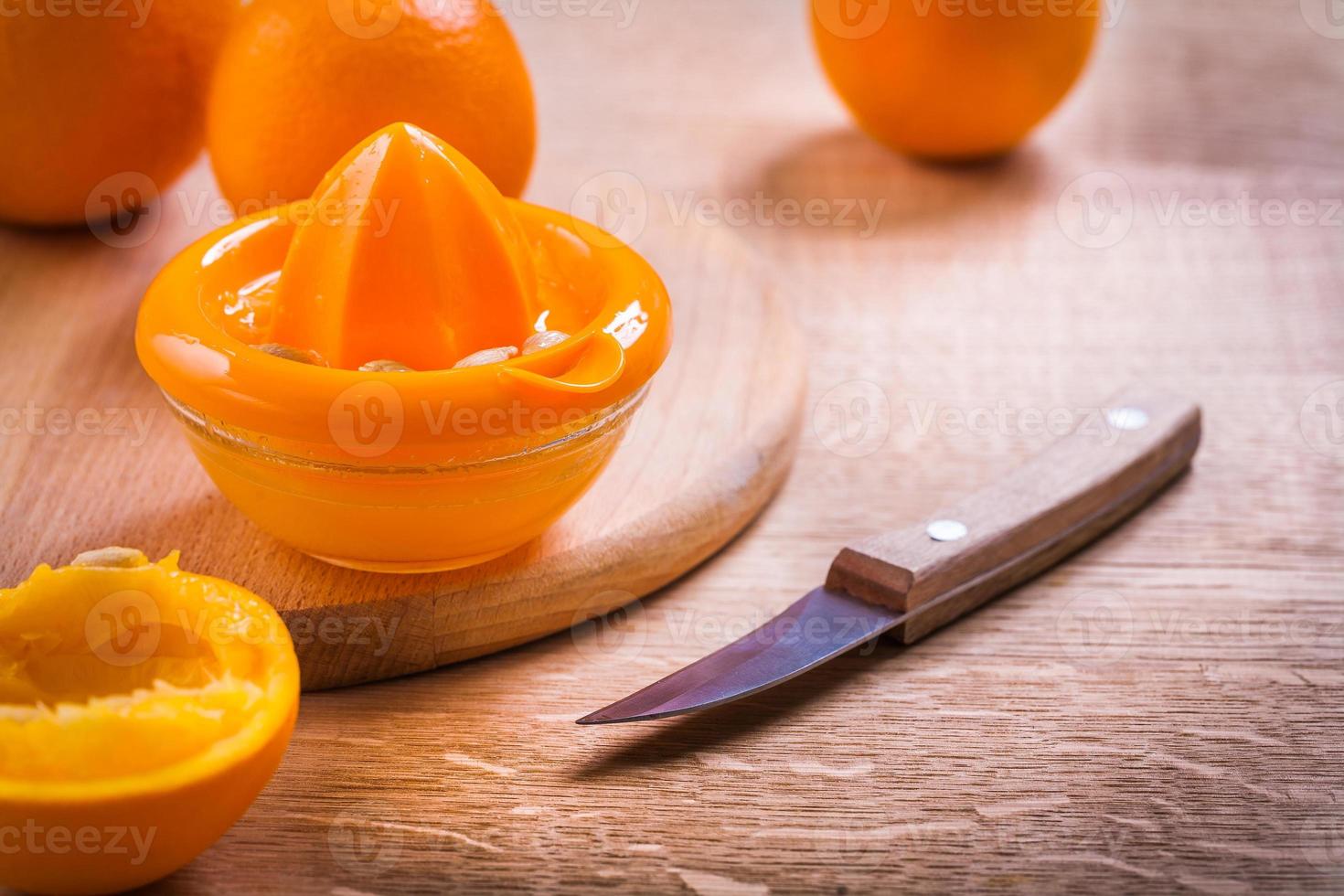 faca espremedor de laranja na mesa de madeira foto