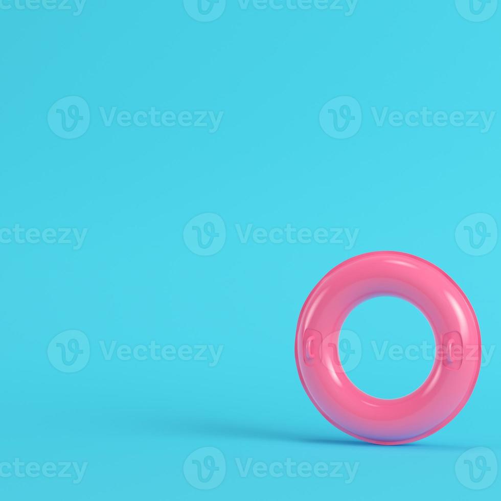 anel inflável rosa sobre fundo azul brilhante em tons pastel foto