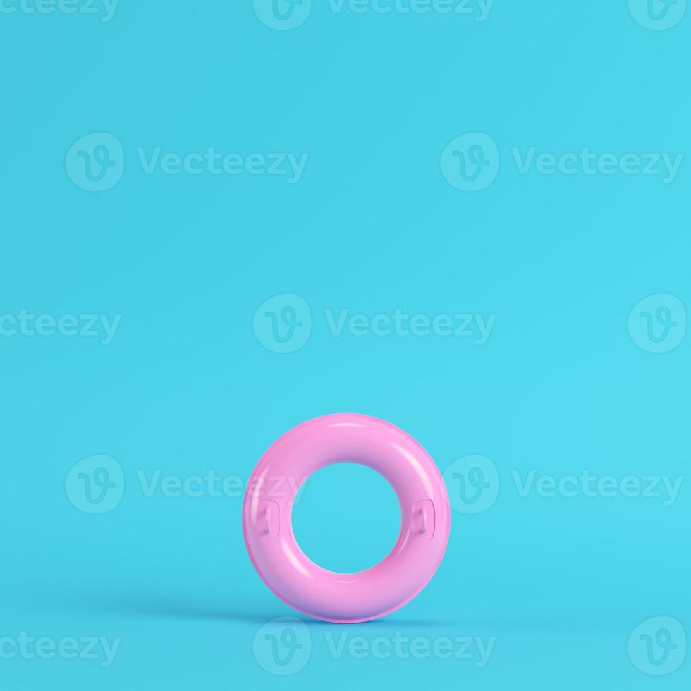 anel inflável rosa em fundo azul brilhante em tons pastel foto