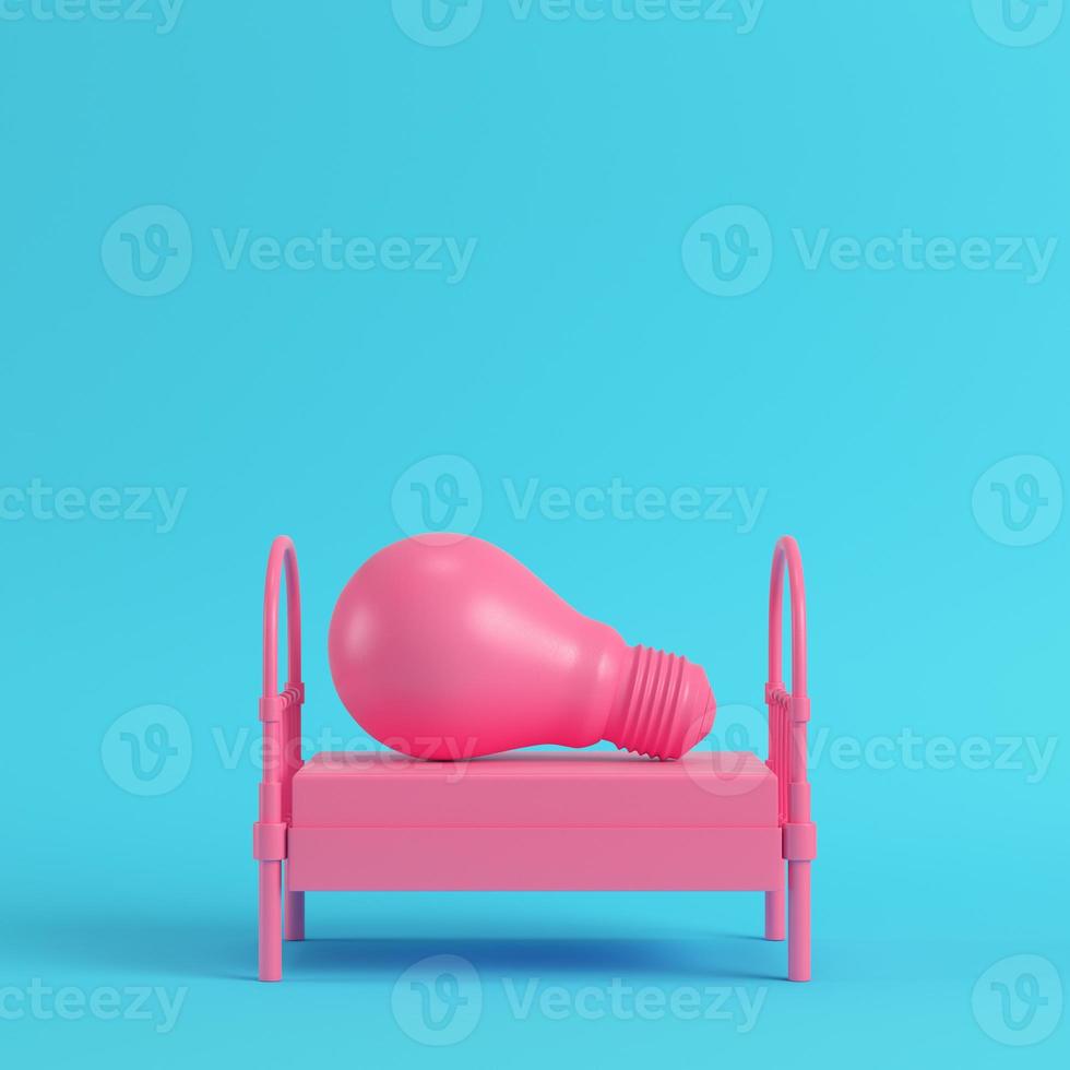 cama de solteiro rosa com lâmpada em fundo azul brilhante em tons pastel foto