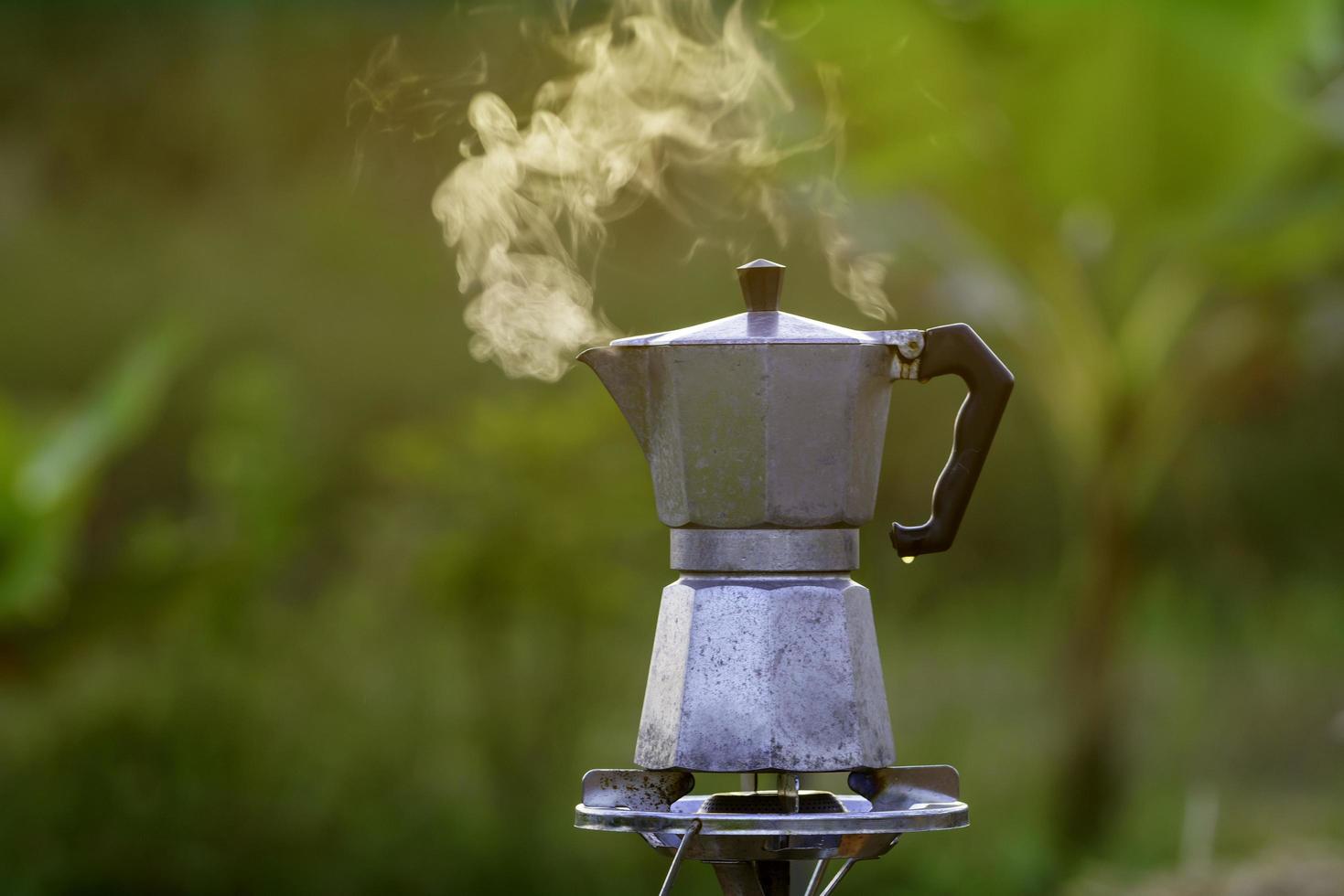 cafeteira moka de café antigo no fogão a gás para acampar quando o sol nasce de manhã. foco suave. foto