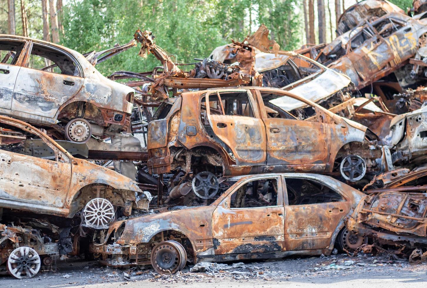 carros queimados enferrujados destruídos por explosões de foguetes. guerra na ucrânia. veículos destruídos de civis que estavam saindo foram evacuados da zona de combate de bucha e irpin. cemitério de carros. foto