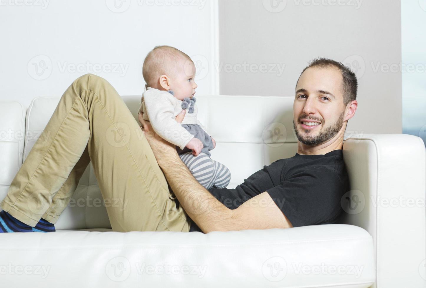 pai com bebê no sofá, tendo um bom tempo foto