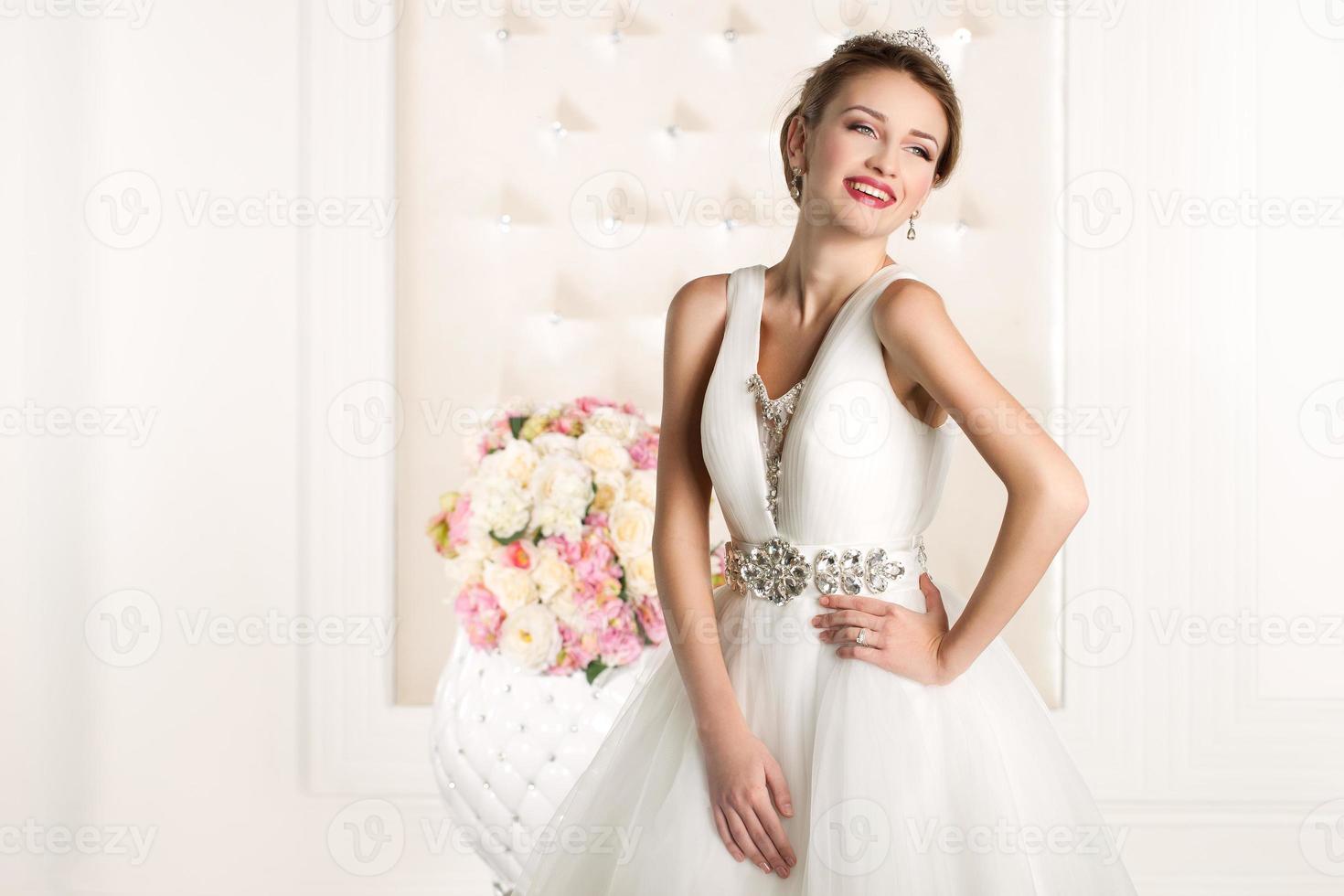 noiva linda com um vestido branco com buquê de flores foto