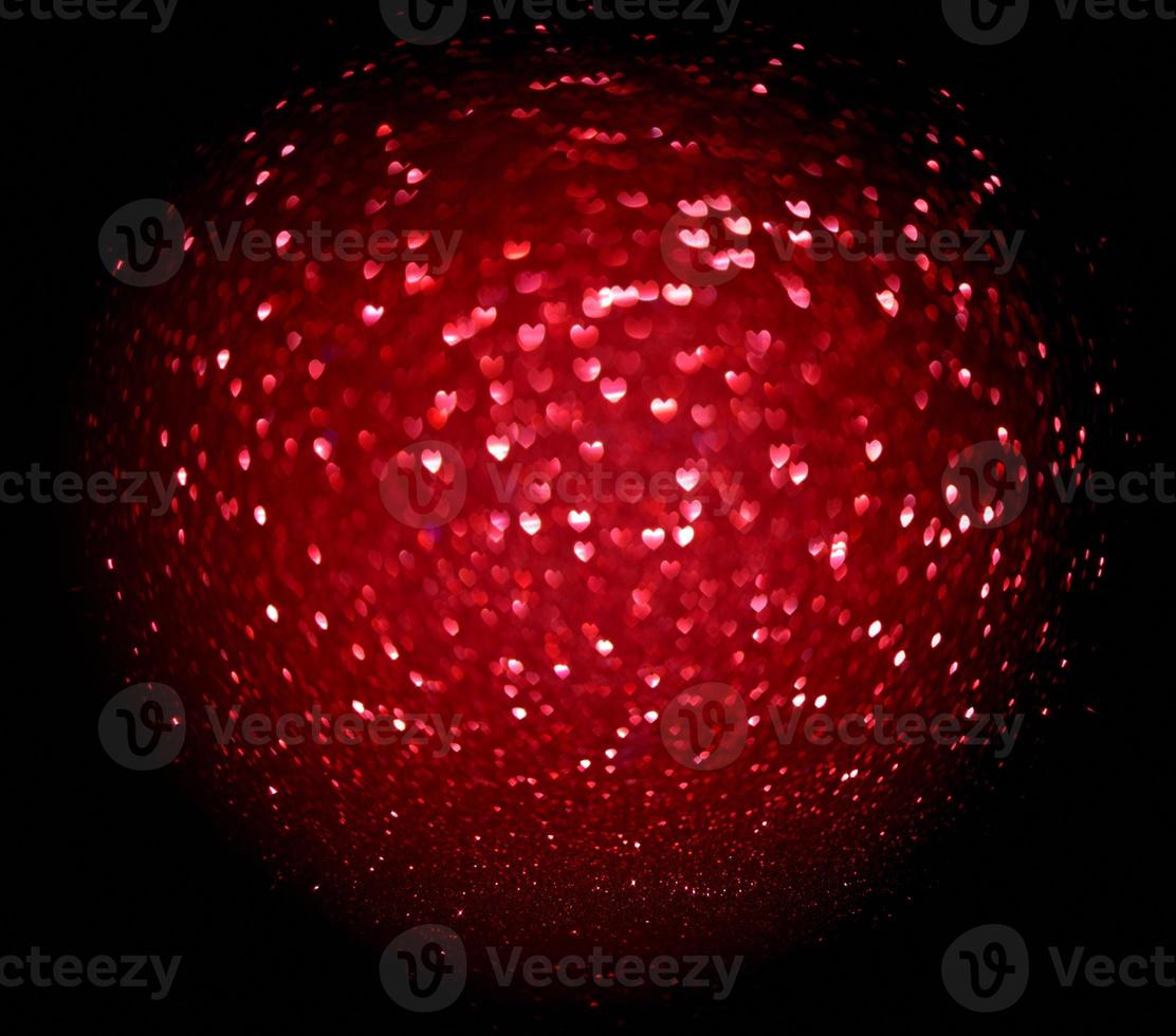 forma de coração de borrão vermelho de ligth bokeh em um fundo preto foto