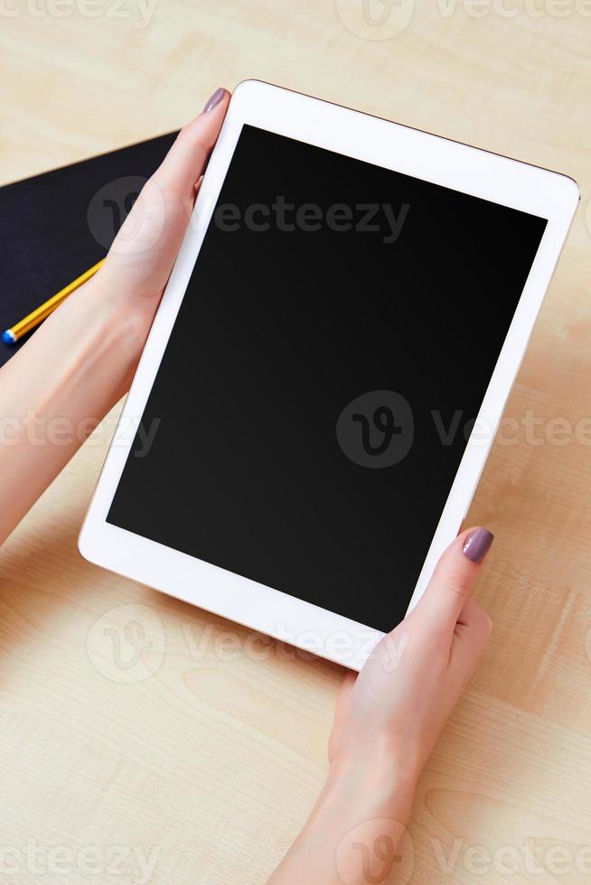 segurando um tablet digital com tela em branco foto